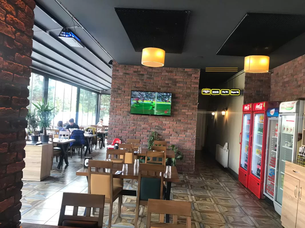 Kafe iç mekânında TV arkası tuğla kaplama uygulaması